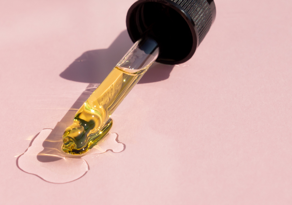 Close-up of a dropper with yellow serum on an article covering why the percentages are important in skincare formulations