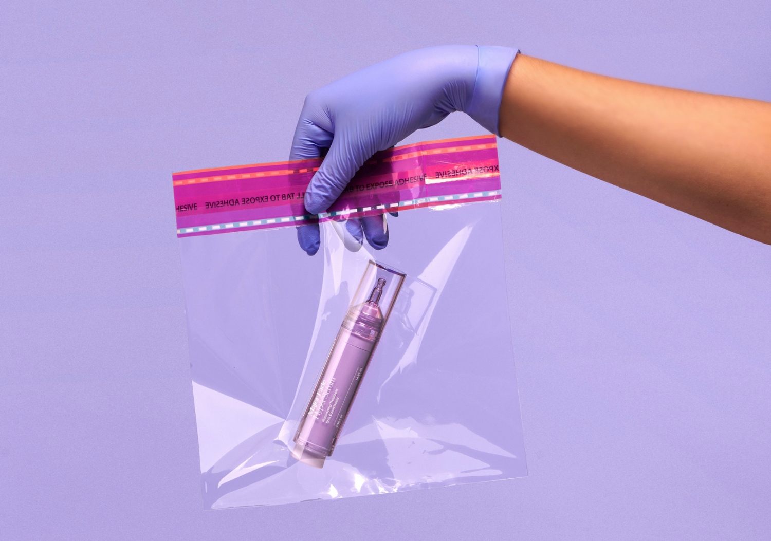 Gloved hand holding a sealed bag containing Dr. Idriss Major Fade Hyper Serum product, covering the thought process and research behind the development of the product