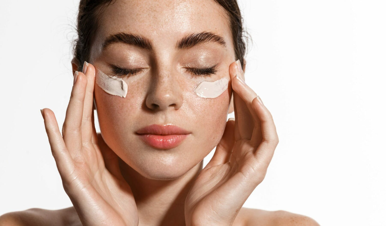 Woman generously applying cream on her undereyes, highlighting top treatments for hyperpigmentation