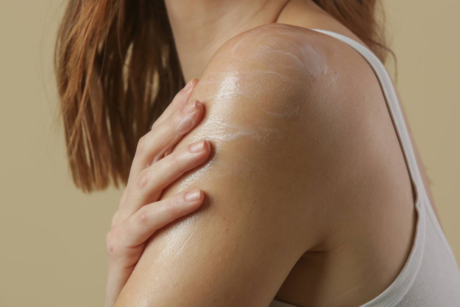 Close-up of a shoulder being moisturized with cream, featuring an article on treating Keratosis Pilaris ("chicken skin")