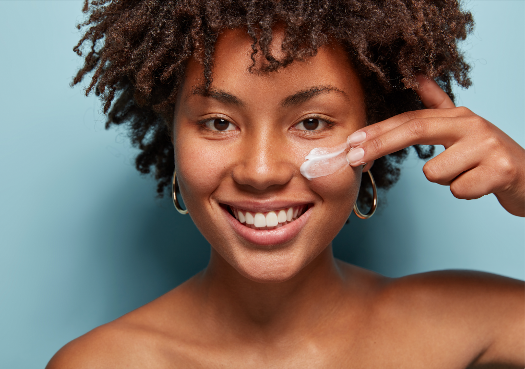 Smiling woman applying under-eye cream, focusing on reducing dark circles and improving skin appearance