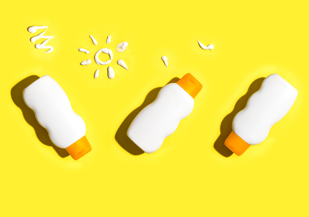 Flat lay of sunscreen bottles on a bright yellow background, featuring an article covering sunscreen recommendations for various skin types and lifestyle