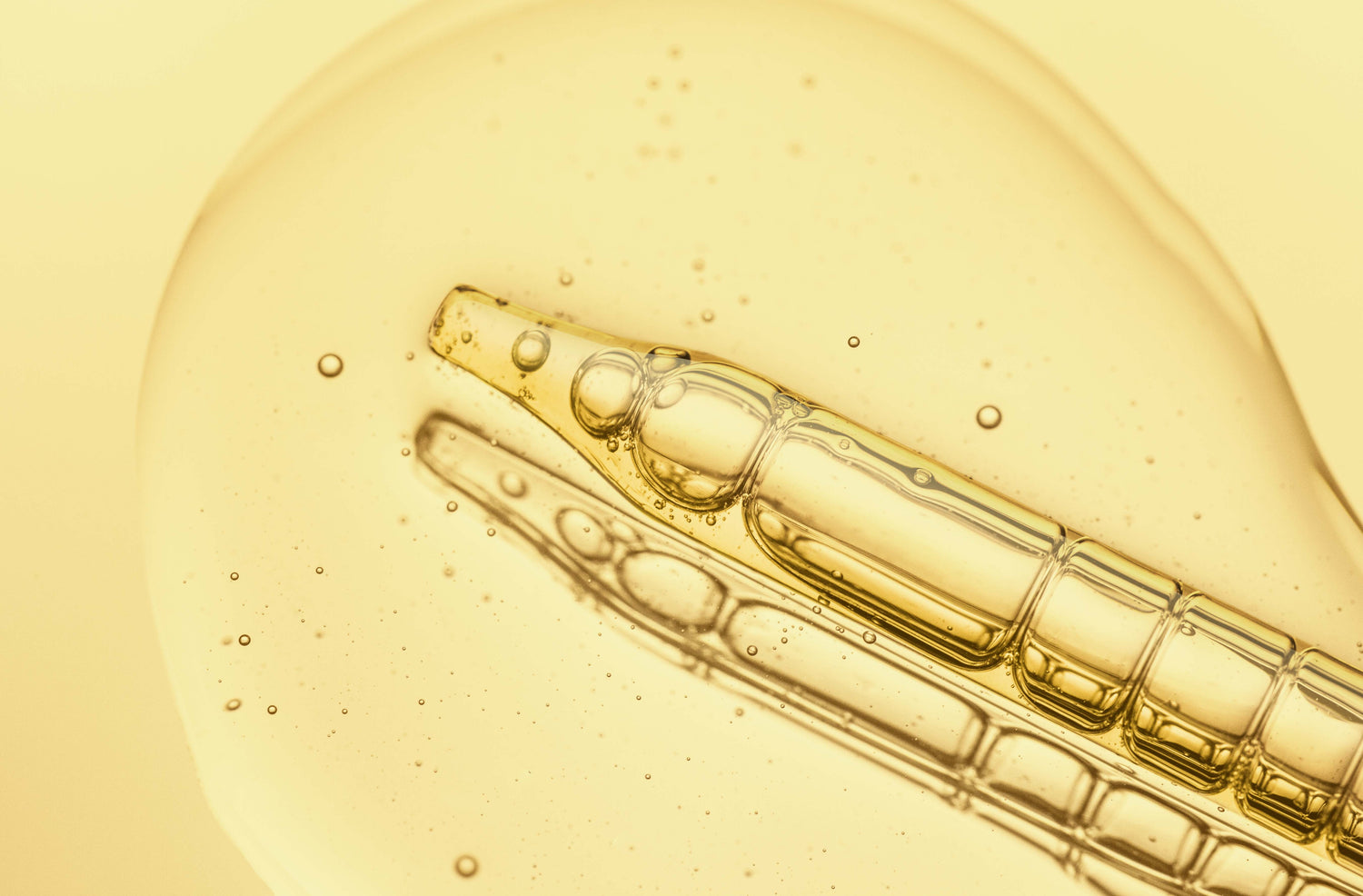 Close-up of clear yellow serum and dropper on an article detailing vitamin C forms and products