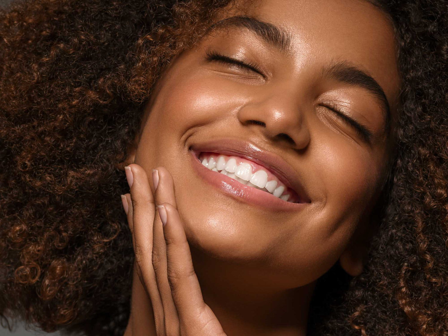Smiling woman with glowing skin representing skincare tips for your 20s