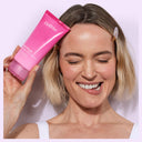 Woman holding Dr. Idriss Soft Wash tube smiling with glowing, clean skin