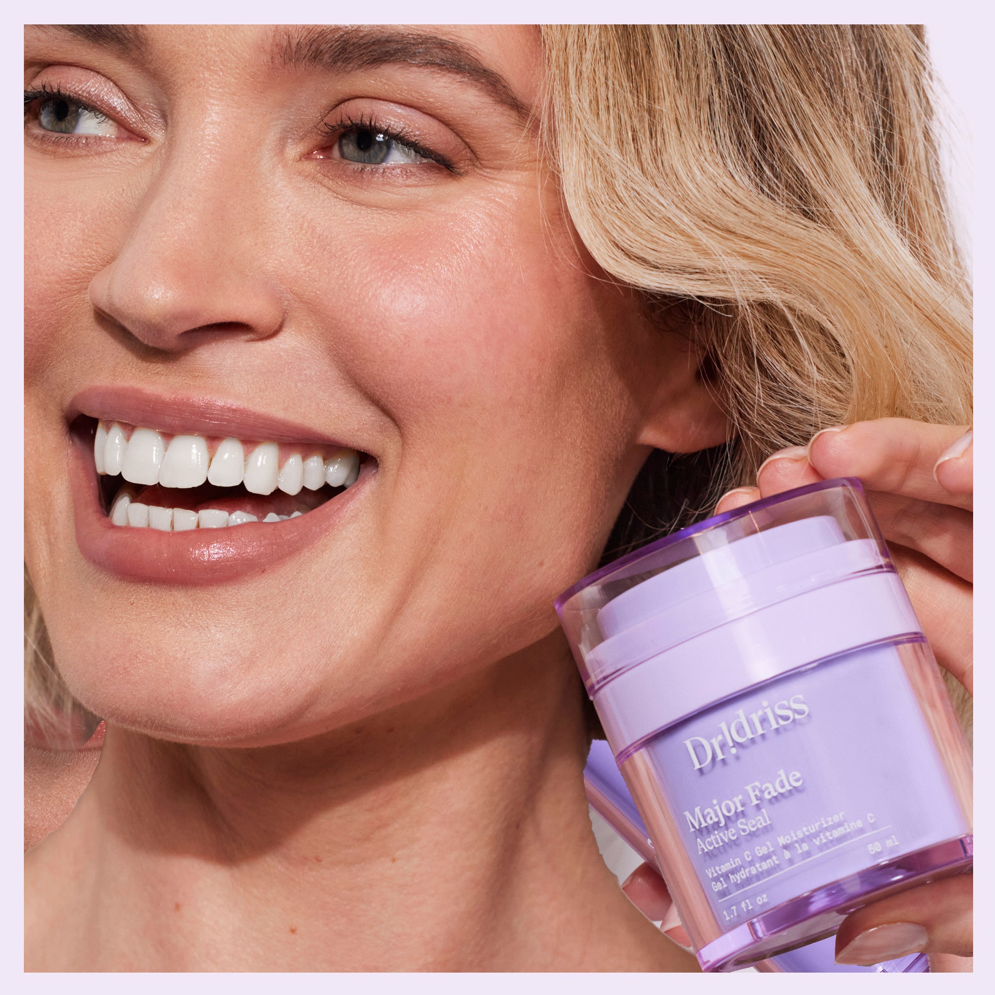 Glowing woman holding Dr. Idriss Major Fade Active Seal vitamin C gel moisturizer to her face