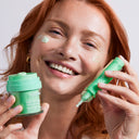 Model wearing the Left Un-Red Reducer Serum and CalmBack Cream, smiling.