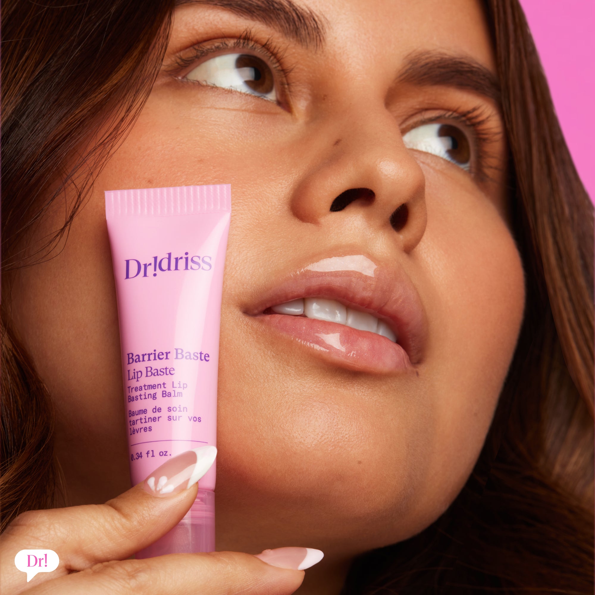 Model holding Dessert Barrier Baste Lip Baste with glossy pink lips