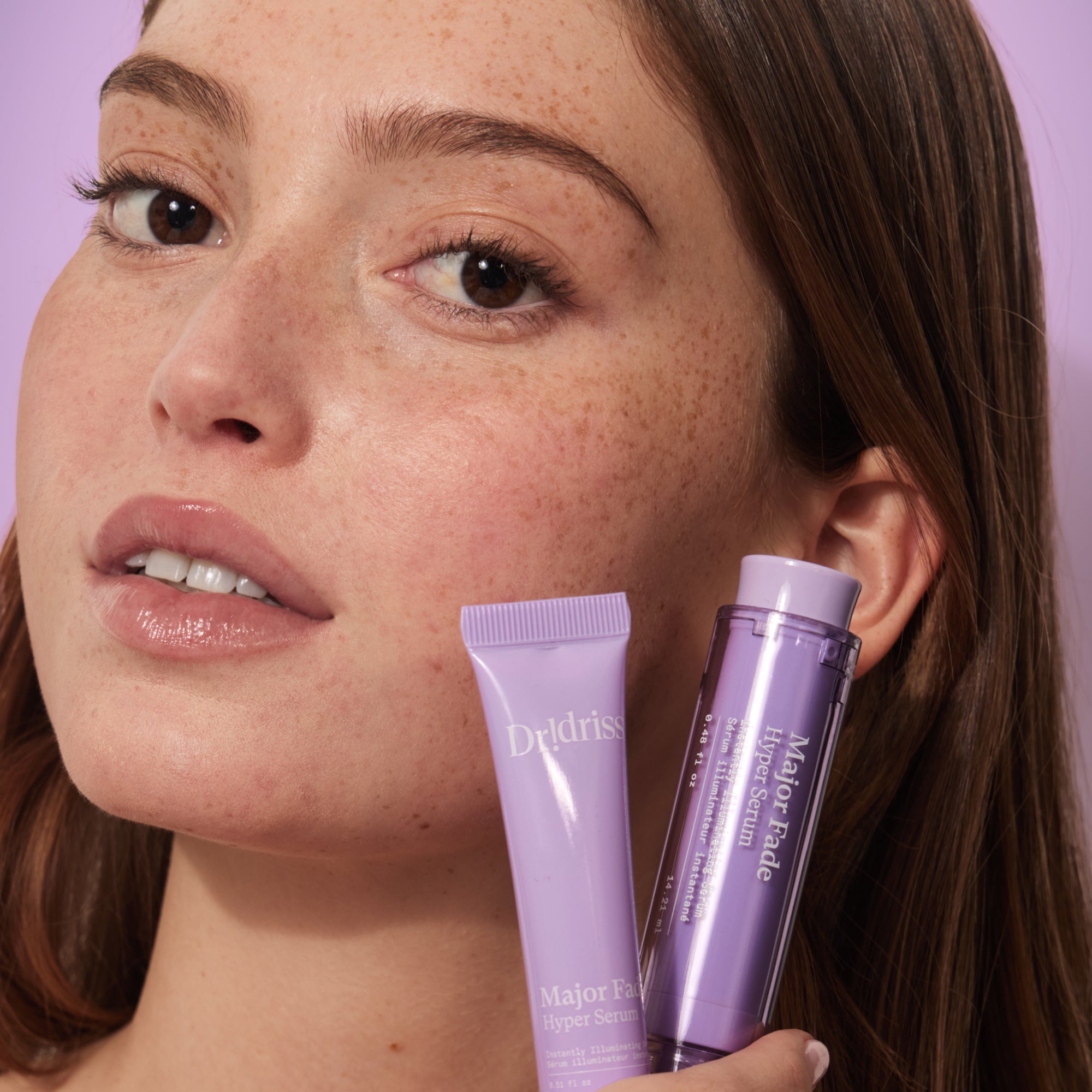 model holding the full size and travel size Hyper Serum
