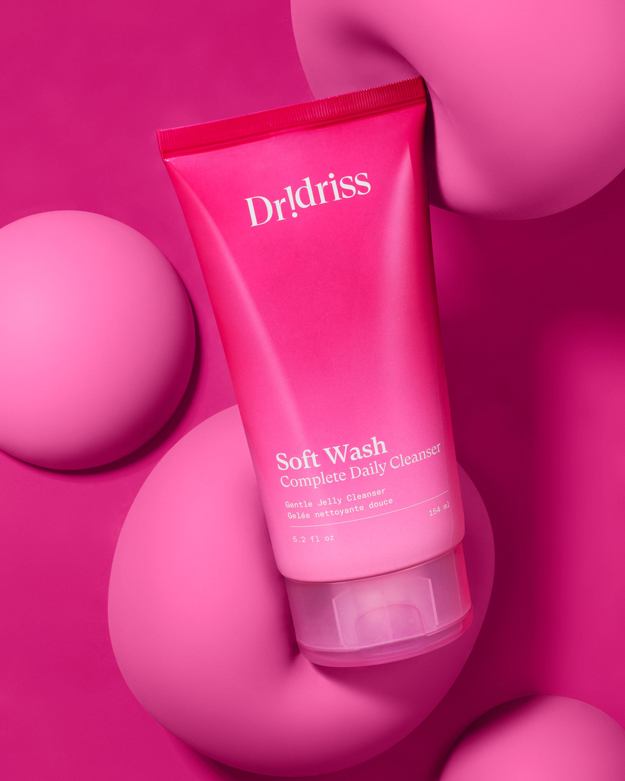 Dr. Idriss Soft Wash Complete Daily Cleanser placed on pink abstract background