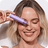 Model holding the Hyper Serum next to her face, smiling
