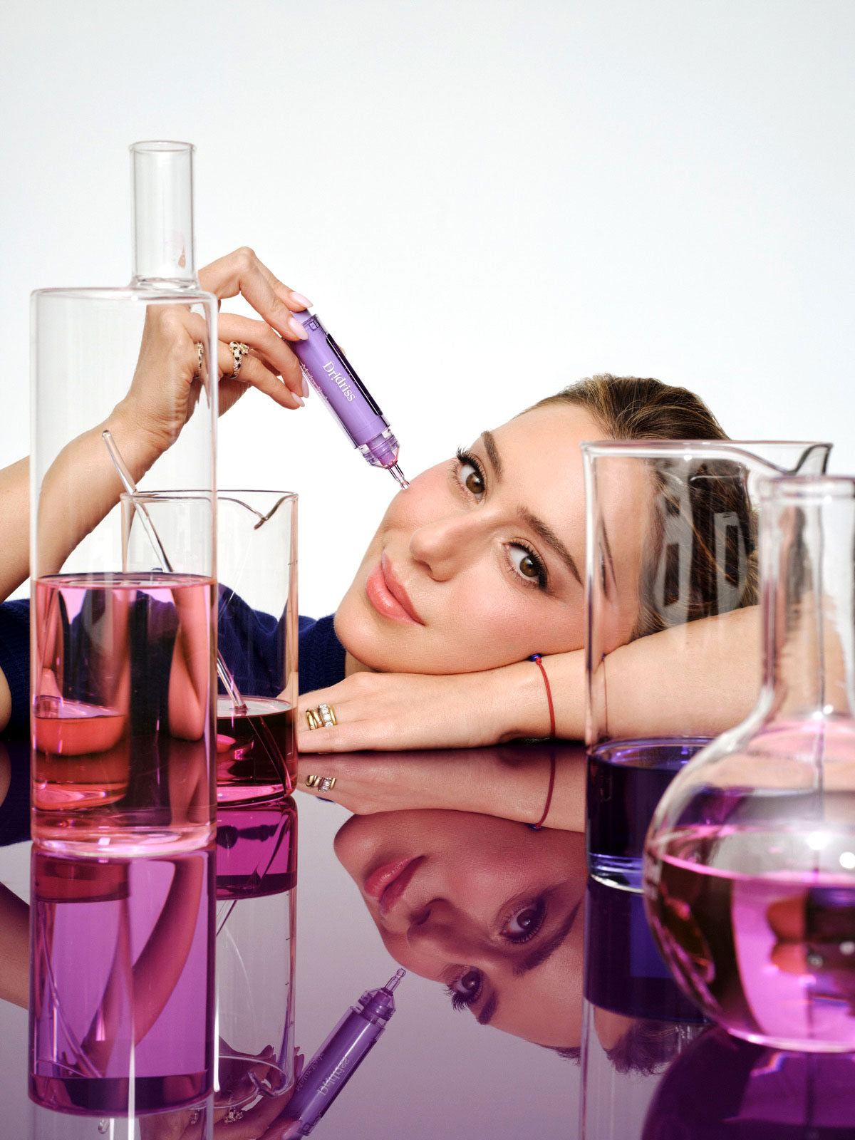 Dr. Shereene Idriss, MD holding Dr. Idriss serum against a purple background